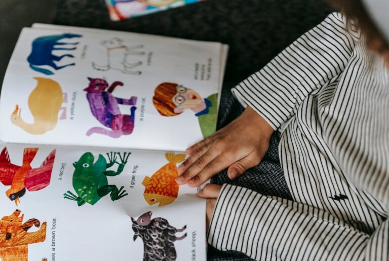 Małe dziecko ogląda kolorową książeczkę – board book dla dzieci 0-3 lat