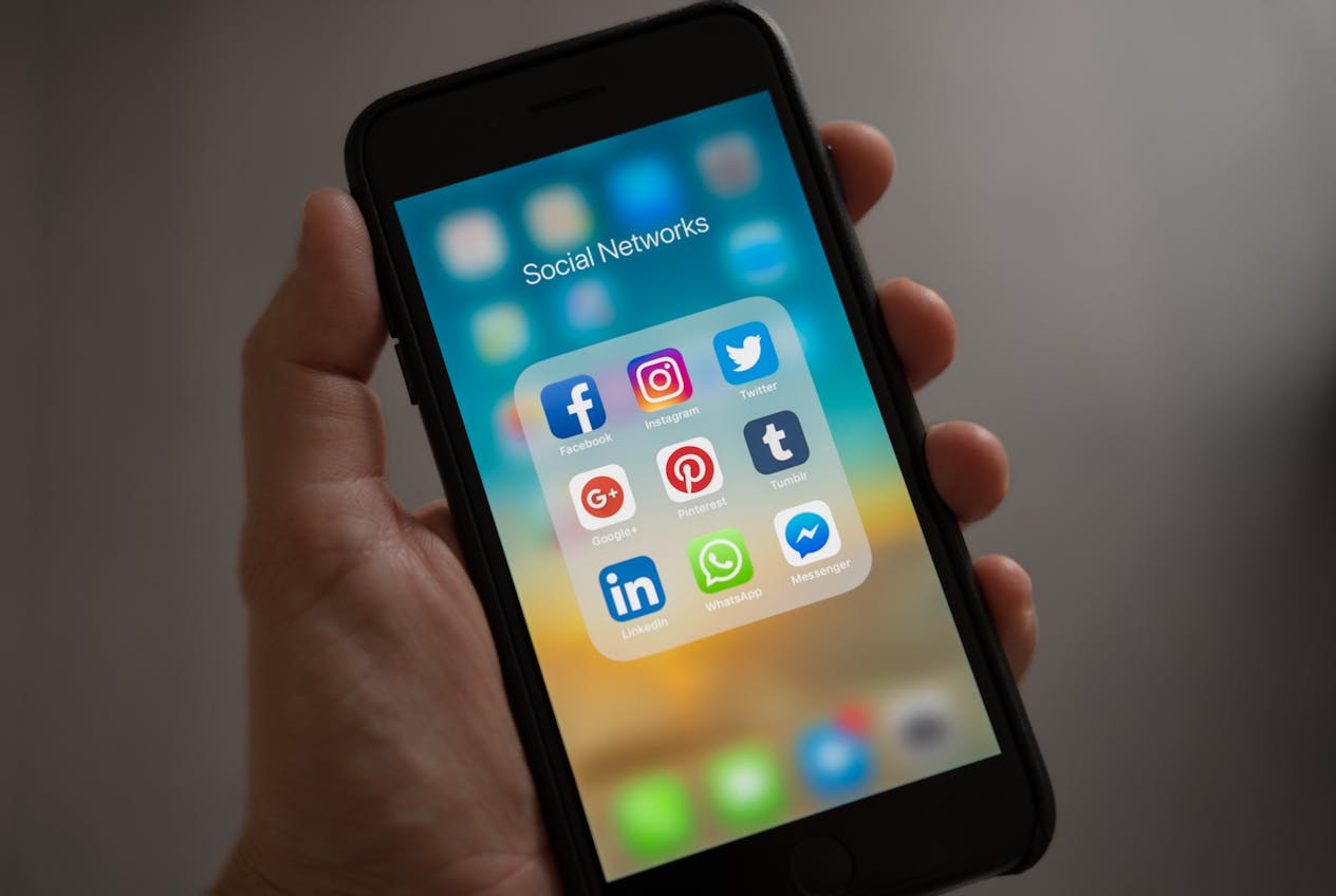 Smartfon z folderem aplikacji społecznościowych – Facebook dla autora książki